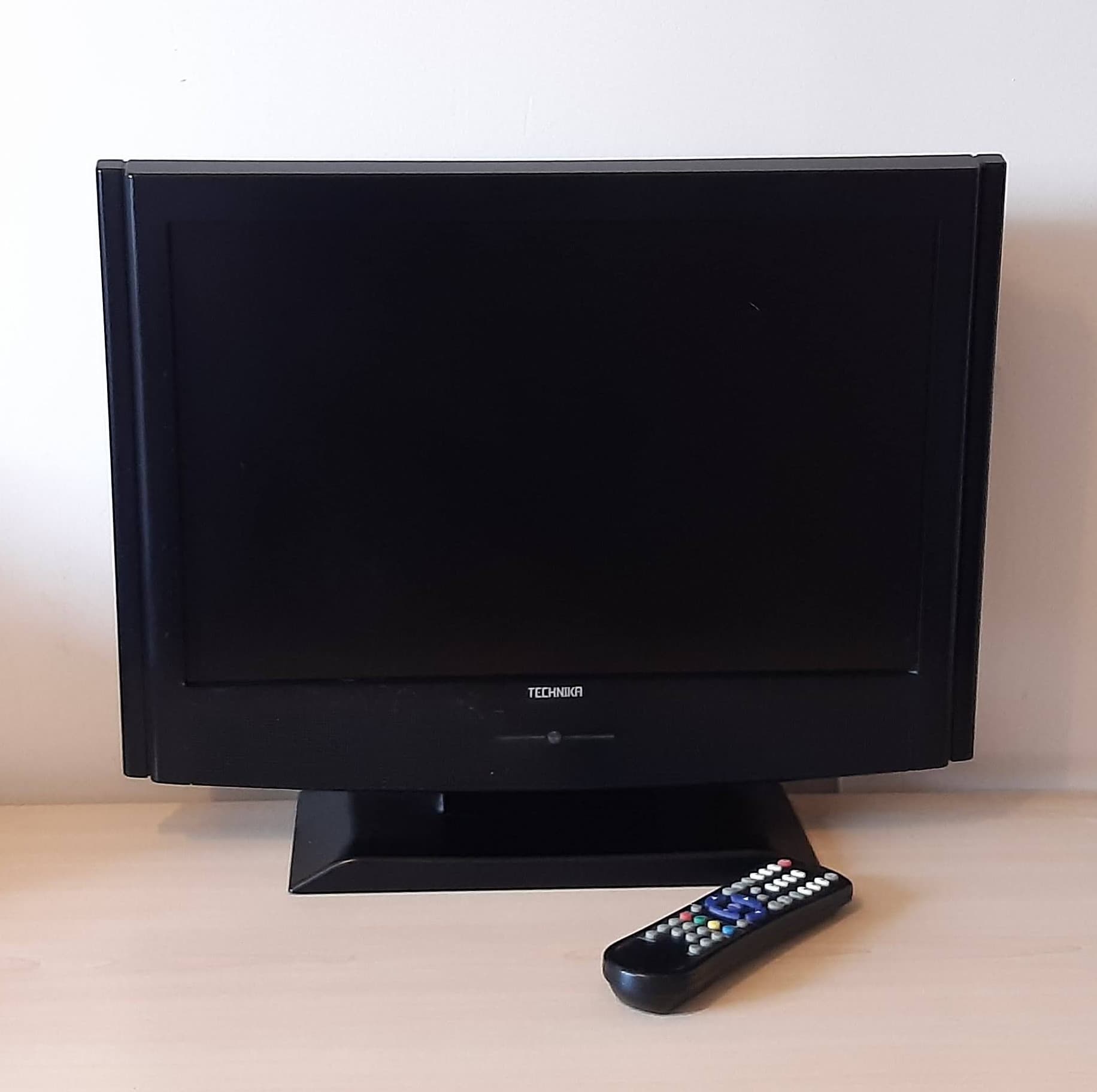 TV with remote control on a table